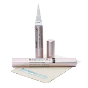 May include: Two pink and white tubes of Sparkle Sparkle Stylus Peppermint + Citrus + Aloe Ultra-concentrated Jewelry Cleaner. The tubes are lying on a white cloth with the Sparkle Sparkle logo.