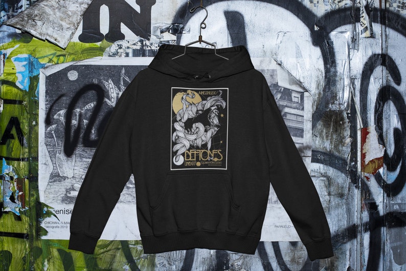 May include: Black hooded sweatshirt with a graphic print of a band called "Deftones" with the words "Angerized" and "Live" printed on the graphic.