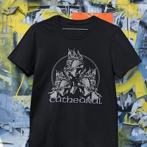 May include: Black t-shirt with a graphic of three figures in a triangle with the word "cathedral" printed below.