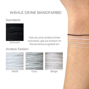 May include: Image displaying bracelet cord colour options. Text reads "W&Auml;HLE DEINE BANDFARBE!" (Choose your band colour!). Standard colour is black, with white, grey, and beige alternatives. Text advises to specify a different colour in the personalisation field.