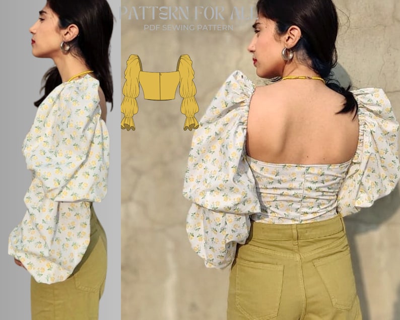 May include: A white top with a floral print and large puffed sleeves. The top has a square neckline and a fitted bodice. The model is wearing the top with high-waisted pants.