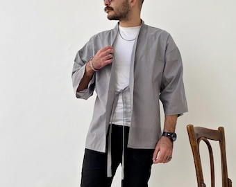 May include: A gray and white striped kimono with a black tie belt. The kimono has a short sleeve and is worn over a white t-shirt.