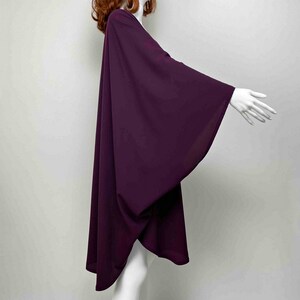 May include: A long, flowing, purple kimono-style top with wide sleeves. The top is made of a soft, lightweight fabric and has a relaxed fit.