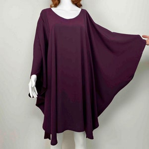 May include: A deep purple, loose-fitting, knee-length dress with a round neckline and long, wide sleeves.