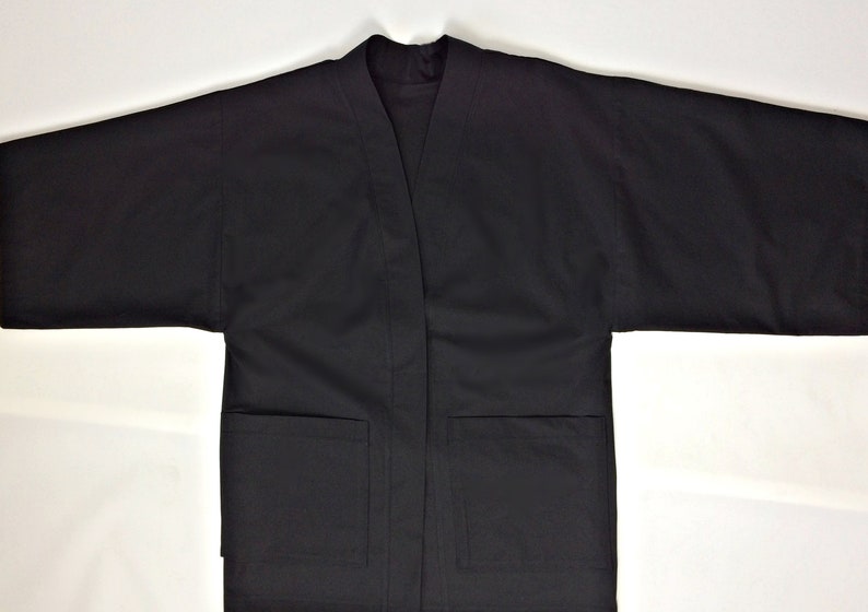 May include: A black, long-sleeved jacket with a V-neck and two pockets.