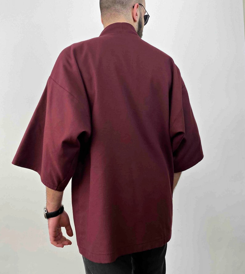 May include: A burgundy short-sleeved kimono-style jacket with a high collar.