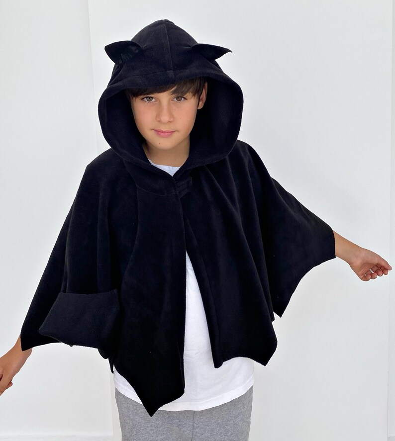 Puede incluir: Capa negra con capucha y orejas de gato, hecha de tejido polar. La capa tiene un dise&ntilde;o largo y fluido, ideal para un disfraz o cosplay.