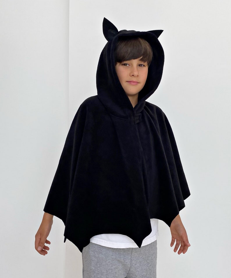 Puede incluir: Capa negra con capucha y orejas de murci&eacute;lago, dise&ntilde;ada para ni&ntilde;os. La capa est&aacute; hecha de suave felpa y tiene un dise&ntilde;o sencillo.