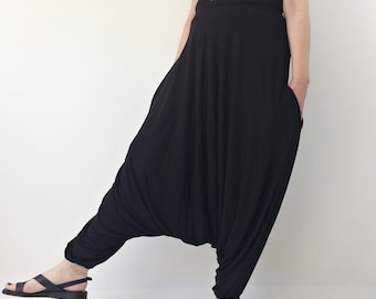 May include: Black harem pants with a loose, flowing fit. The pants are made of a soft, comfortable fabric and have a wide, elastic waistband.