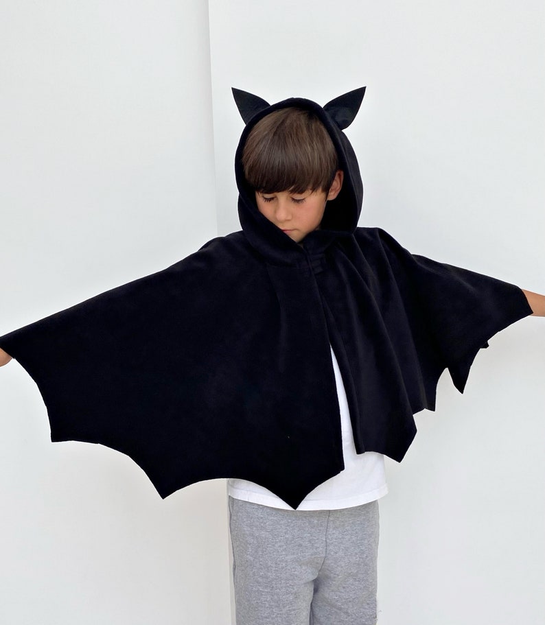 Puede incluir: Un disfraz de murci&eacute;lago negro para ni&ntilde;os con una capa con capucha y orejas de murci&eacute;lago. La capa tiene un dise&ntilde;o de alas de murci&eacute;lago.