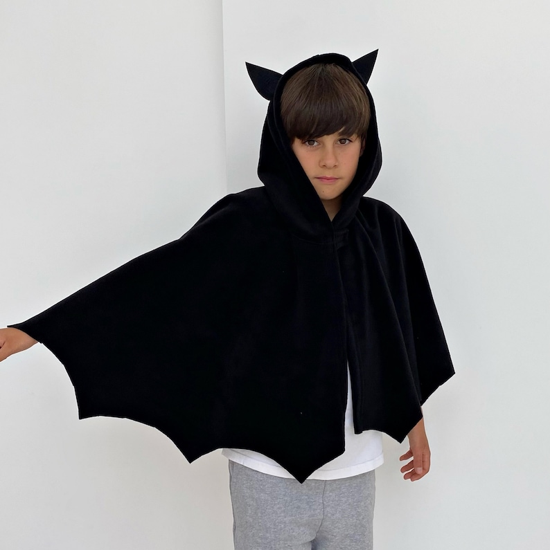Puede incluir: Una capa negra con capucha y alas de murci&eacute;lago, perfecta para disfraces de Halloween. La capa tiene una capucha puntiaguda con orejas de murci&eacute;lago y un dise&ntilde;o largo y fluido.