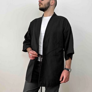 May include: A black kimono-style jacket with a long tie belt. The jacket has a relaxed fit and is made of a soft, lightweight fabric.