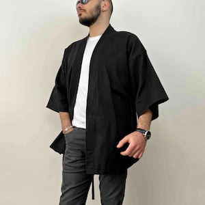 May include: A black kimono with long sleeves and a tie belt. The kimono is made of a lightweight fabric and has a relaxed fit.