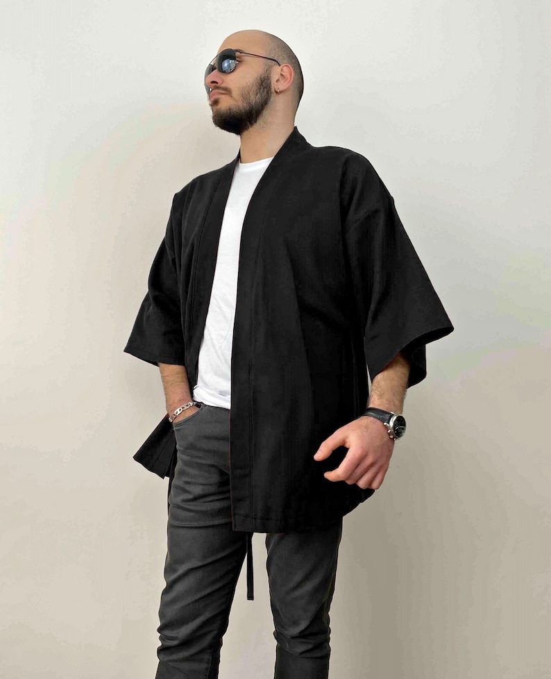 May include: A black kimono with long sleeves and a tie belt. The kimono is made of a lightweight fabric and has a relaxed fit.