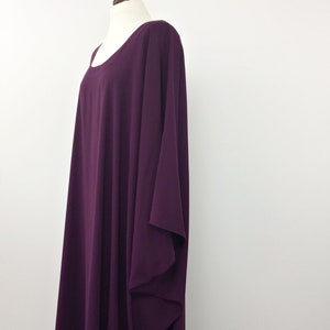 May include: A long, flowing, purple dress with a scoop neck and a loose, flowing fit. The dress is made of a soft, lightweight fabric.