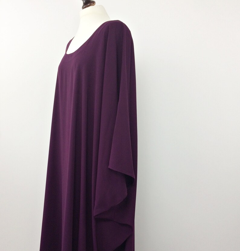May include: A long, flowing, purple dress with a scoop neck and a loose, flowing fit. The dress is made of a soft, lightweight fabric.
