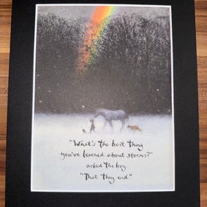 Puede incluir: Impresión enmarcada con una ilustración caprichosa de un niño, un caballo y un zorro en un paisaje nevado bajo un arcoíris. El texto dice: "¿Qué es lo mejor que has aprendido sobre las tormentas?" "¡Que terminan!"