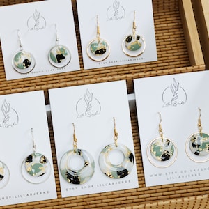 Puede incluir: Cuatro pares de pendientes redondos colgantes de color verde, negro y dorado, expuestos en tarjetas blancas con el texto "Etsy Shop: Lillabjerke" y "www.etsy.co.uk/shop/lillabjerke".