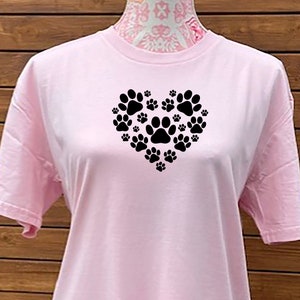 May include: Pink t-shirt with a black paw print design in the shape of a heart.