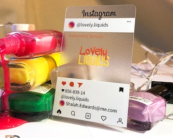 Può includere: Un biglietto da visita in plastica trasparente con sfondo satinato. Il biglietto presenta un'icona di social media con il testo "Instagram" e il nome utente "@lovely.liquids". Il biglietto include anche il testo "Servizi di Barman" e il logo "Lovely Liquids". Il biglietto ha un numero di telefono, un indirizzo email e icone di social media.