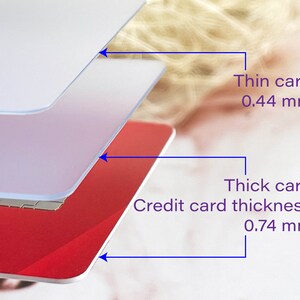 May include: Close-up of three layers of plastic cards, showing the thickness of a standard credit card, which is 0.74 mm, and a thinner card, which is 0.44 mm.
