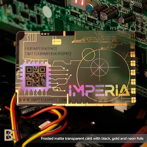 K&ouml;nnte beinhalten: Eine mattierte, transparente Karte mit schwarzen, goldenen und Neon-Folienakzenten. Die Karte zeigt ein holografisches Design mit einem QR-Code, dem Text "IMPERIA AEROSPACE" und der Website-Adresse "WWW.IMPERIASPACE.COM".