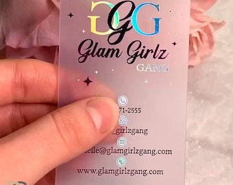Może przedstawiać: Wizytówka z matowego plastiku z holograficznym różowym i neonowym wzorem. Wizytówka zawiera tekst "GG Glam Girlz GANG" oraz dane kontaktowe, w tym numer telefonu, adres e-mail i stronę internetową.
