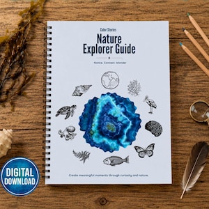 May include: A spiral-bound Nature Explorer Guide notebook with a white cover featuring the text Color Stories Nature Explorer Guide, Notice. Connect. Wonder, and Create meaningful moments through curiosity and nature, surrounding a blue agate graphic.