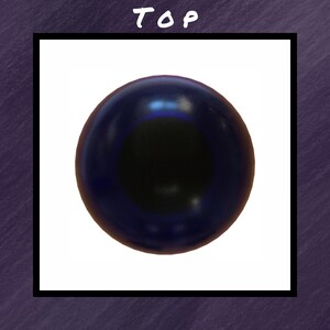 Puede incluir: Una esfera azul oscuro con un centro negro, sobre un fondo blanco dentro de un marco negro. La palabra "TOP" est&aacute; escrita en blanco en la parte superior. El fondo es morado texturizado.
