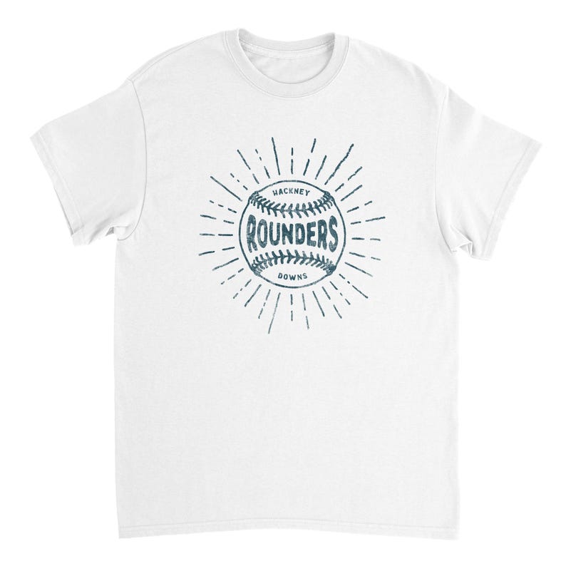 May include: A white short-sleeve t-shirt featuring a dark blue graphic of a baseball with the text "HACKNEY ROUNDERS DOWNS" printed in the center. The design includes radiating lines extending outward from the ball in a sunburst pattern.