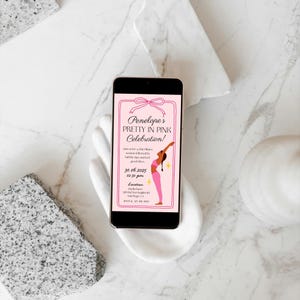 Puede incluir: Un smartphone muestra una invitaci&oacute;n rosa para "Penelope's Pretty in Pink Celebration!". La invitaci&oacute;n presenta un lazo, un gr&aacute;fico de bailarina y detalles del evento. El tel&eacute;fono se sostiene en una escultura blanca con forma de mano sobre un fondo de m&aacute;rmol.