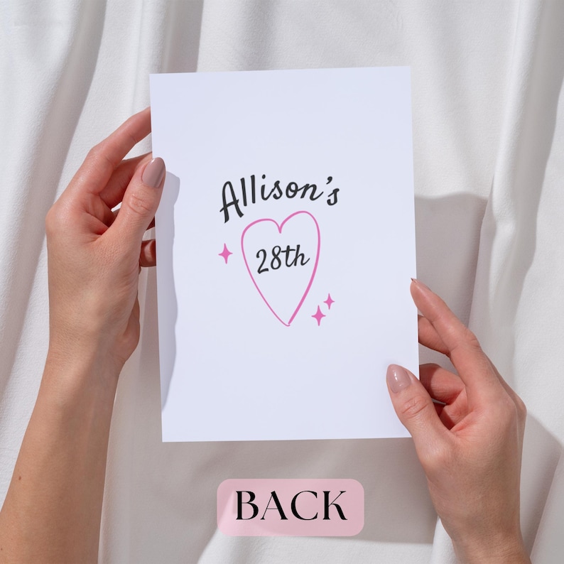 May include: A white card with the text "Allison's 28th" in black and pink. The number 28 is inside a pink heart. The word "BACK" is printed in pink at the bottom of the card.