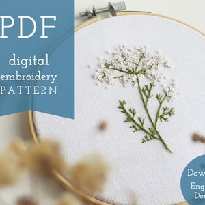 Könnte beinhalten: Ein digitales Stickmuster für eine weiße Blume mit grünen Stielen, dargestellt in einem hölzernen Stickrahmen. Das Muster ist in Englisch und Deutsch verfügbar. Der Text "PDF digital embroidery PATTERN" wird auf blauem Hintergrund angezeigt.