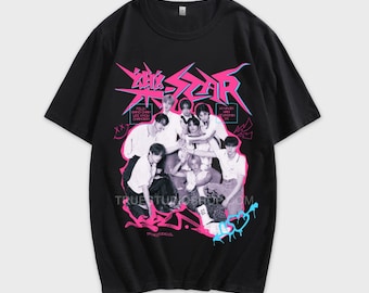 May include: Black t-shirt with a graphic print of a K-pop boy band in front of a pink and blue graffiti design. The text "Stray Kids" is printed in pink and blue letters. The band members are wearing casual clothing and are posing in a group.