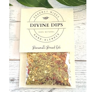 May include: A small white pouch with a clear plastic window showing a blend of dried herbs and spices. The pouch has a label that reads "Gourmet Mixes Divine Dips 100% Natural Hand-Blended Beramati Bread Oil."