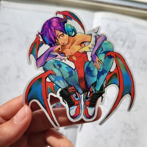 May include: A colorful sticker featuring a cartoon character with purple hair, red wings, and blue and red clothing. The character is wearing sneakers and has a playful expression.