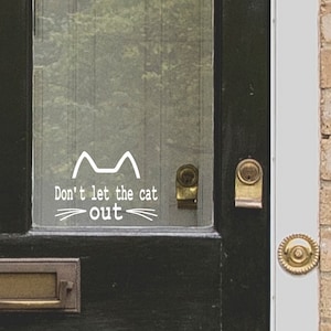 May include: A black door with a glass panel featuring a white cat silhouette and the text "Don't let the cat out".