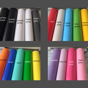 K&ouml;nnte beinhalten: Eine Auswahl an Vinylfarben in Rollen, darunter gl&auml;nzend Schwarz, matt Schwarz, gl&auml;nzend Wei&szlig;, matt Wei&szlig;, Schiefergrau, Rot, Hellgrau, Babyblau, Limettengr&uuml;n, Warm Gelb, Orange, Blau, Mintgr&uuml;n, Gelb, Lila, Mauve, Dunkelrosa und Hellrosa.