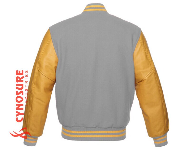 May include: A gray varsity jacket with yellow leather sleeves and yellow and white striped trim. The jacket has a classic varsity style.