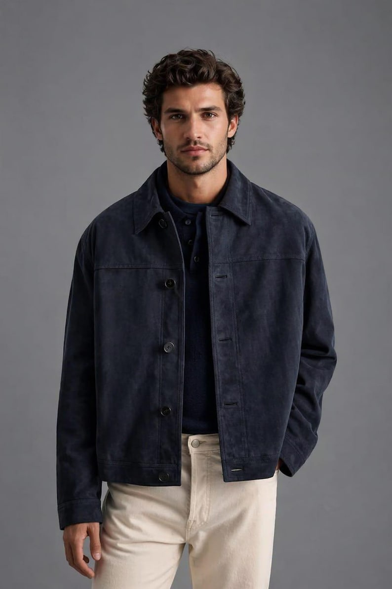 Pu&ograve; includere: Una giacca in camoscio blu navy con chiusura a bottoni e colletto. La giacca &egrave; abbinata a una camicia blu scuro e pantaloni beige chiaro. Il design della giacca &egrave; semplice e classico, adatta a varie occasioni.