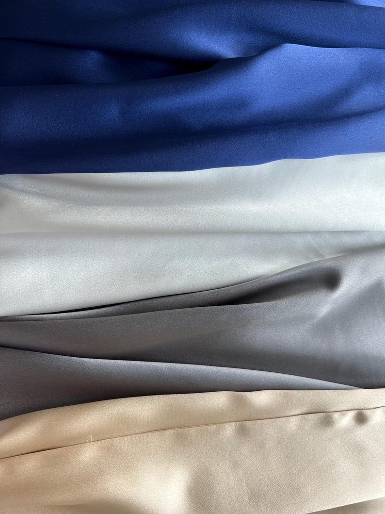 K&ouml;nnte beinhalten: Vier Stoffmuster in verschiedenen Farben. Das oberste Muster ist dunkelblau, das zweite ist hellwei&szlig;, das dritte ist hellgrau und das unterste Muster ist hellbeige.