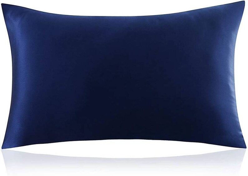 K&ouml;nnte beinhalten: Ein dunkelblauer Kissenbezug aus Satin. Der Kissenbezug ist glatt und knitterfrei.