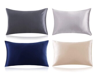 May include: Four satin pillowcases in different colors: gray, silver, navy blue, and beige. The pillowcases are arranged in two rows of two.