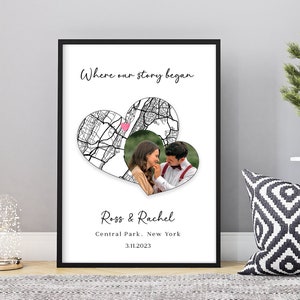 May include: A black framed print with a white background featuring a map of a city in the shape of a heart. The heart is divided into two halves, with a photo of a couple in the right half. The text "Where our story began" is at the top of the print, and the text "Ross & Rachel, Central Park, New York, 3.11.2023" is at the bottom.