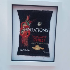 Op de afbeelding: Een geborduurd beeld van een zak chips met de tekst "Sensations Thai Sweet Chilli" en de datum "22/05/22".