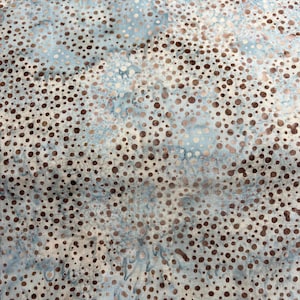 May include: A blue and brown fabric with a polka dot pattern. The dots are a darker brown color and are scattered randomly across the fabric.