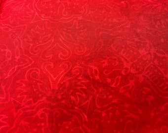 May include: Red fabric with a subtle embossed pattern of swirling floral designs.