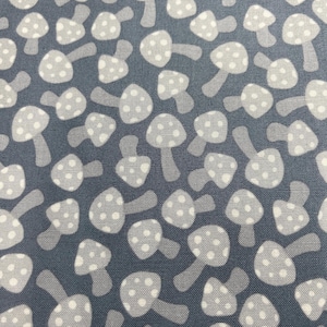 May include: A blue fabric with a white mushroom pattern. The mushrooms are stylized and have white dots on them.