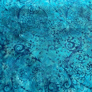 May include: A piece of fabric featuring a vibrant turquoise and deep blue batik pattern. The design consists of intricate, swirling spiral motifs and organic, fern-like shapes that repeat across the entire surface of the textile material.