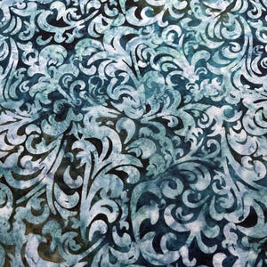May include: A blue and white fabric with a swirling, floral pattern. The fabric has a batik-style design with a dark blue background and white swirls.
